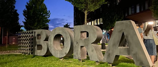 The large BORA sign in the garden of the BORA Academy in Germany